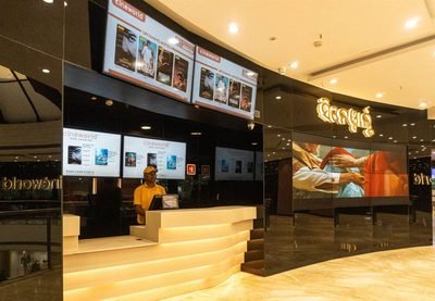 Cinèworld box office counter with lit screens showing films now playing