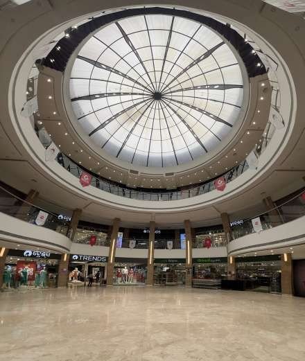 Circular atrium of FE2 Arcade under a large glass dome, with store fronts including Trends on two levels